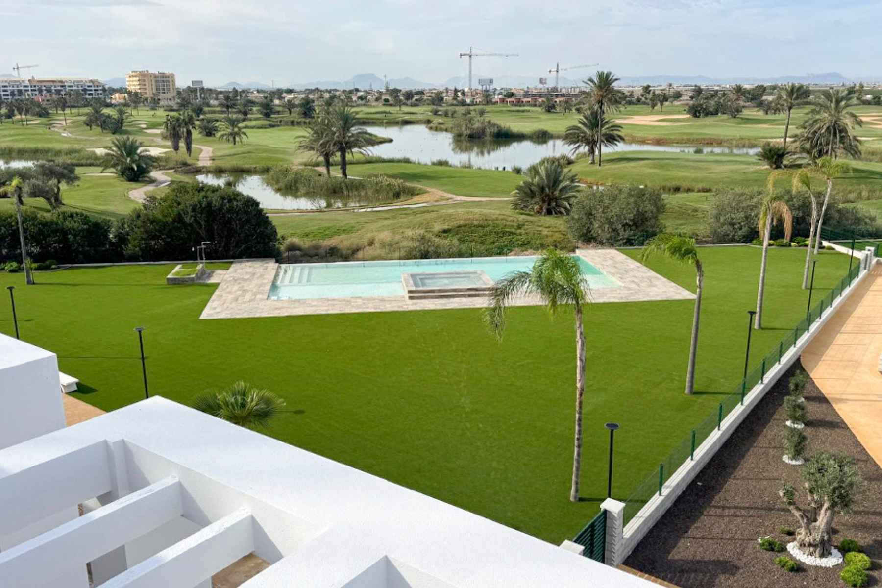 Zona ajardinada y piscina del residencial en Los Alcázares